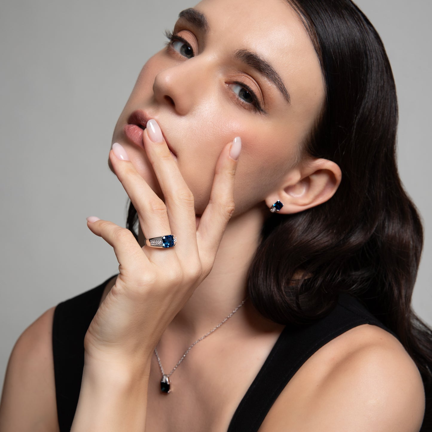 Le Petite Folie: London Blue Topaz Emerald Cut 4-Prong Ear Huggie Studs with White Topaz Accents in Rhodium Plated 925 Silver