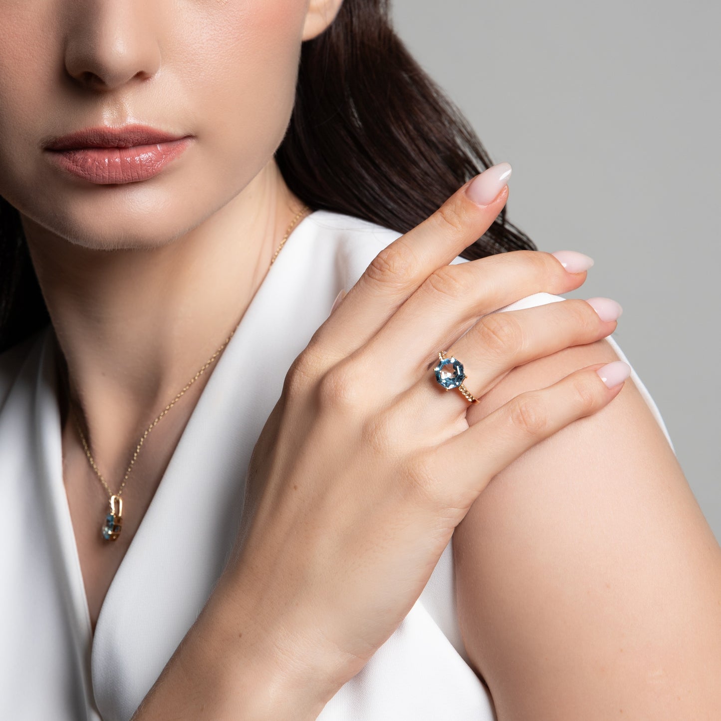 Novalty: Light Blue Topaz Round Cut 4-Prong Solitaire Ring with White Topaz Shoulders in 18K Yellow Gold